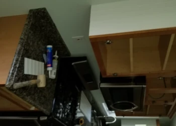 Partially stripped kitchen cabinets and countertops in Merrimack, NH during cabinet refinishing project