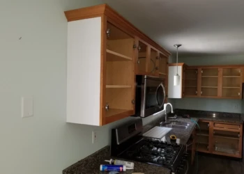 Open kitchen cabinets with decorative bead board trim on island side in Merrimack kitchen