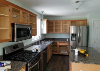 Wood kitchen cabinets with opened doors and drawers around granite countertops in a kitchen in Merrimack NH