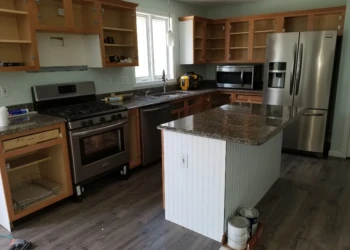 Kitchen with open wooden cabinets and a bead board island undergoing cabinet refinishing Merrimack NH