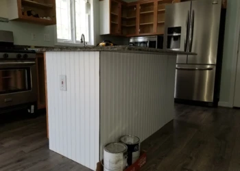 Kitchen island with newly installed white bead board paneling and granite countertop in Merrimack home