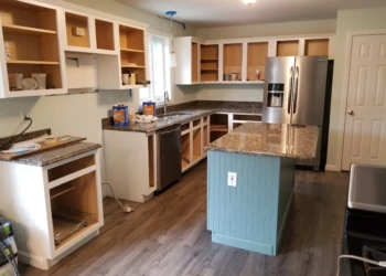 Kitchen cabinets without doors and hardware in Merrimack kitchen undergoing cabinet refinishing and island with decorative bead board