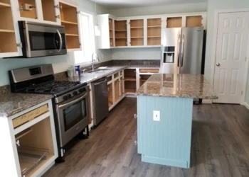 Kitchen with empty refinished cabinets and painted bead board island in Merrimack, NH
