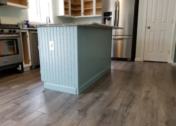 Kitchen island with newly refinished cabinet featuring a decorative bead board panel and granite countertop in Merrimack kitchen
