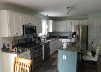 Kitchen showing white refinished cabinets and a blue decorative bead board island with granite countertop in Merrimack NH kitchen