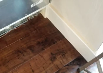 Close-up of dark stained refinished custom kitchen cabinet doors and baseboard in Newton MA kitchen remodeling project