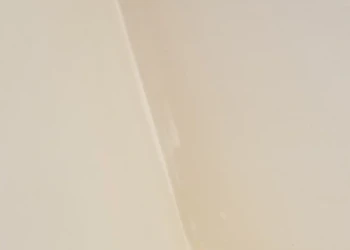 Close-up view of a beige cabinet surface showing a smooth finish during refinishing work