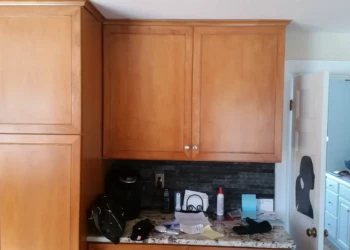 Cherry wood kitchen cabinets with warm finish and silver knobs in a Sudbury MA home