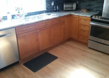 Refinished cherry wood kitchen cabinets with stainless steel appliances and granite countertop in a Sudbury kitchen