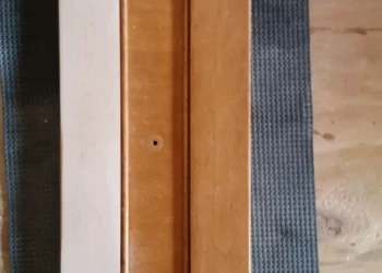 Cherry wood cabinet door half sanded showing transition between original finish and raw wood during cabinet refinishing in Sudbury MA