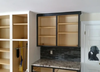 Kitchen cabinets with open shelves and black outer trim above granite countertop in Sudbury MA kitchen