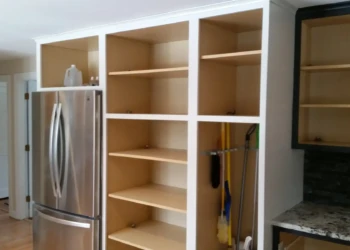 Empty kitchen cabinet frames next to refrigerator and countertop in a Sudbury MA kitchen prepared for cabinet refinishing