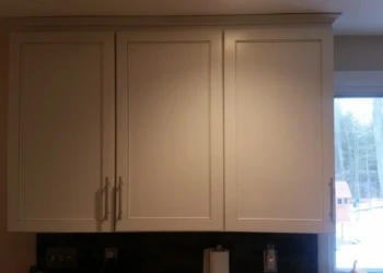 Repainted kitchen cabinets with smooth beige finish and modern hardware in a Sudbury MA kitchen