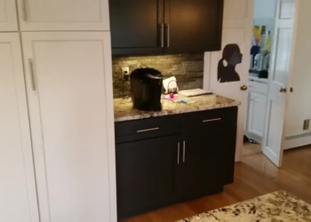 Kitchen cabinets with black lower and white upper units paired with granite countertops in a Sudbury MA home