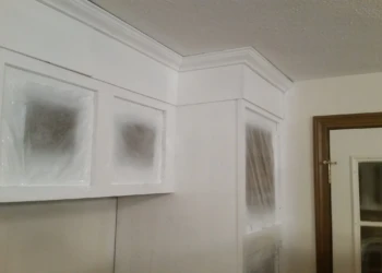 Upper kitchen cabinets masked with plastic sheeting ready for cabinet refinishing painting in Westford MA