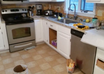 Partially refinished white kitchen cabinets with some doors removed in a Westford MA kitchen during cabinet refinishing painting