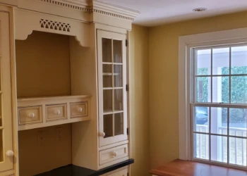 Refinished kitchen cabinets with glass panel doors and white finish in a Weston MA home kitchen corner