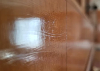 Close-up view of a cabinet surface with visible brush strokes and uneven varnish finish in Wilmington kitchen