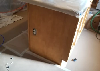 Wooden kitchen island cabinet partially stripped and prepared for cabinet refinishing in Wilmington MA