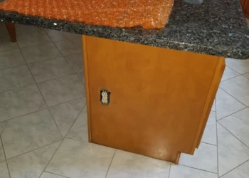 Wooden kitchen cabinet base with a granite countertop and tile flooring in Wilmington MA