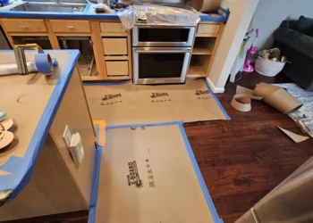 Kitchen cabinets stripped down, with drawers removed and covered surfaces ready for cabinet refinishing in Windham NH