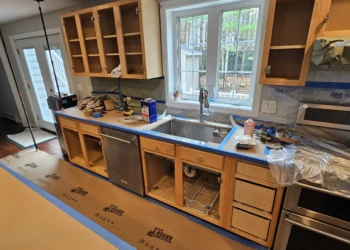 Kitchen with stripped wood cabinets and drawers in preparation for refinishing in Windham NH