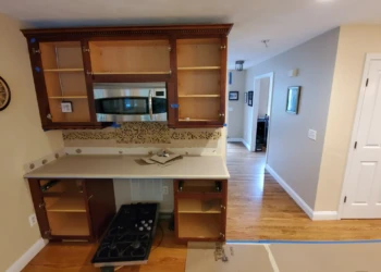 Kitchen cabinetry in Windham NH with all cabinet and drawer doors removed, showing bare cabinet boxes and countertop