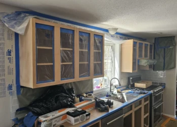 Bare wood kitchen cabinets masked and prepped for refinishing in Windham NH home