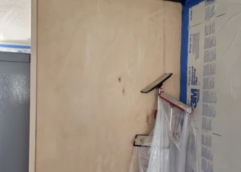 Sand-smooth bare wood cabinet surface in preparation for refinishing at Windham NH project