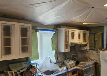 Kitchen cabinets being primed with protection sheets in Windham NH cabinet refinishing project