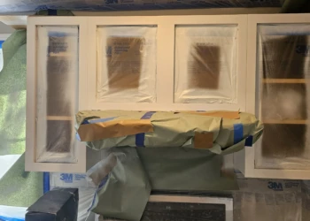 Kitchen cabinet doors masked and prepped for finishing during cabinet refinishing project in Windham NH