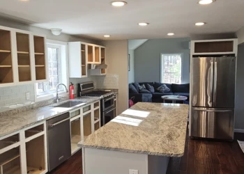 Kitchen with white cabinets stripped of doors and drawers during cabinet refinishing in Windham NH