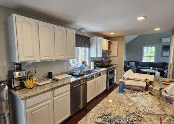 White refinished kitchen cabinets along with granite countertops and stainless steel appliances in Windham NH kitchen