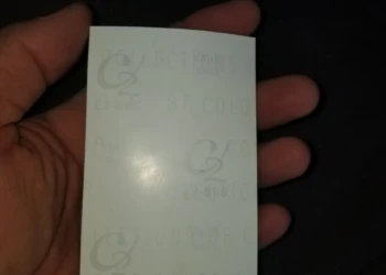 Close-up of a hand holding a cabinet refinishing sample card.