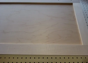 Wood cabinet being sanded and prepared for refinishing.