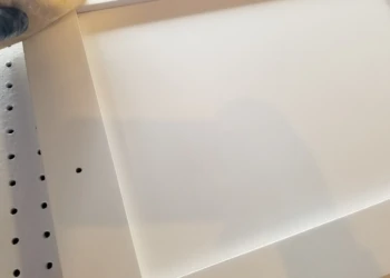 Close-up of a cabinet being refinished with a smooth, white finish.