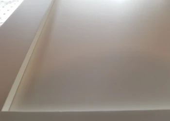 Close-up of a cabinet being refinished with a smooth, painted surface.