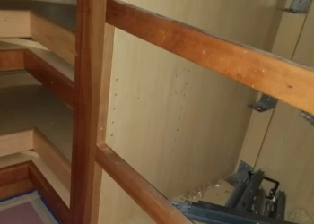 Wooden cabinet frame being sanded and prepared for refinishing.
