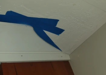 Ceiling drywall taping and finishing with blue painter's tape.