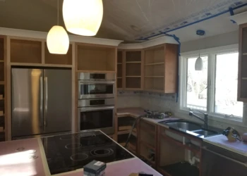 Kitchen cabinets being refinished with new paint and finish.