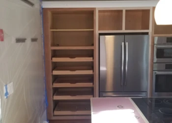 Unfinished wooden cabinets being refinished in a kitchen.
