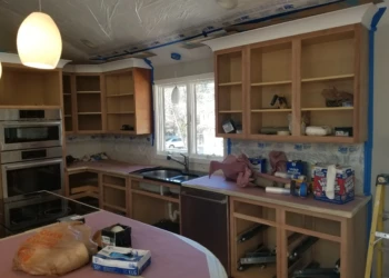 Kitchen cabinets being refinished with new paint and finish.