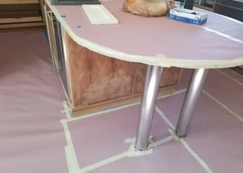 Kitchen island cabinet being refinished with new paint and protective coating.