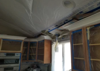 Kitchen cabinets being sanded and prepared for refinishing.