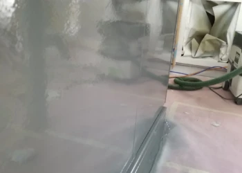 Refinished kitchen cabinet with a smooth, glossy gray finish.