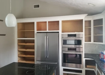 Kitchen cabinets being refinished with paint and sealant.