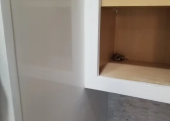 Close-up of a cabinet being refinished in a kitchen.