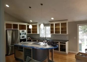 Kitchen cabinets being refinished in a modern kitchen.