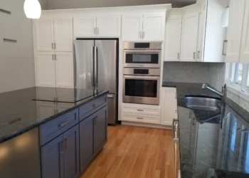 Kitchen cabinet refinishing service with white cabinets and granite countertops.