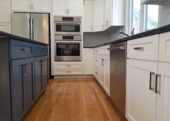 Kitchen cabinets being refinished with white and blue paint in a modern kitchen.